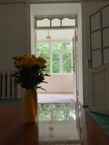 a vase of flowers sitting on a table in front of a door at family homestay in Osh