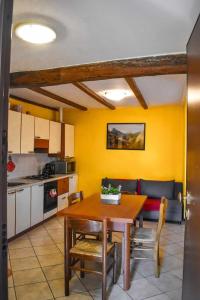 韋爾巴尼亞的住宿－Ciceri Properties Ciancino，厨房以及带木桌的用餐室。
