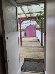 una puerta abierta a una casa con un cobertizo rosa en The Art House 5 Galway, Bohermore en Galway