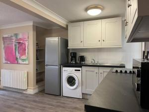 a kitchen with a refrigerator and a washing machine at The Art House 5 Galway, Bohermore in Galway