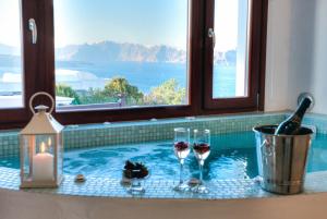 una piscina con dos copas de vino y una vela en William's Houses, en Akrotiri