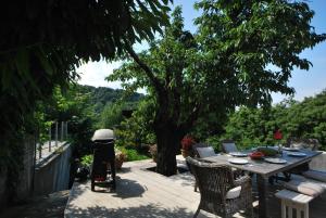 une table et des chaises sur une terrasse avec un arbre dans l'établissement ARKPelion, à Tsagkarada