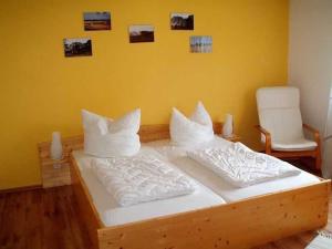 a bedroom with a wooden bed with white pillows at Ruegen Fewo 108 1 in Zudar
