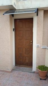 a brown door of a house with a potted plant at Il Nido in Olbia