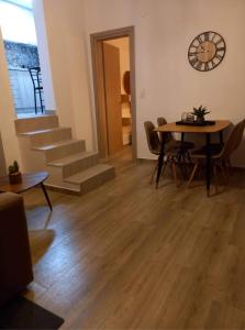 a living room with a table and chairs and a clock at Rafailia's House in Kallirakhi