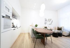 a kitchen and living room with a wooden table and chairs at Modern 5min Wenceslas Square APT in Prague