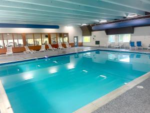 een groot zwembad met blauw water in een gebouw bij Alpine Lake Cabin Mountain Resort w Lake Access in Terra Alta