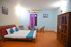 sypialnia z łóżkiem, stołem i krzesłami w obiekcie Les Boganveillea Heritage Guest House w mieście Auroville