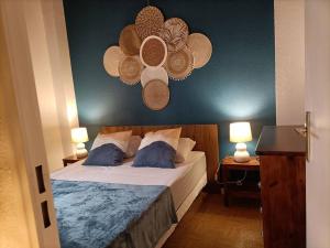 ein Schlafzimmer mit einem Bett mit einer blauen Wand in der Unterkunft Le Sept in Gruissan + 14 Fotos