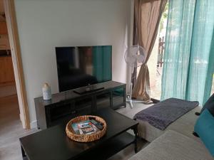 ein Wohnzimmer mit Fernseher und Couchtisch in der Unterkunft Le Sept in Gruissan