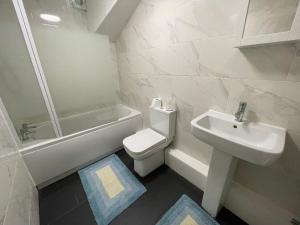 uma casa de banho com um lavatório, um WC e uma banheira em The Crescent, Flat 1 - Stockport, Manchester em Manchester
