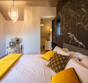 a bedroom with a large white bed with yellow pillows at La Maison de Florence in Angers