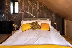 Un dormitorio con una cama con almohadas amarillas. en La Maison de Florence en Angers