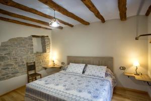 um quarto com uma cama e uma parede de pedra em Casa rural La Masadría em Mondot