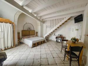 a large room with a bed and a staircase at Novecento Room and Breakfast Puglia in Massafra