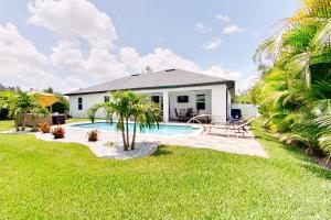 ein Haus mit einem Pool und Palmen in der Unterkunft Stress-free Estate in Matlacha
