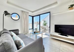 a living room with a couch and a tv at North Coast Apartments in Puerto de la Cruz