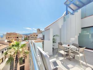 a balcony with a table and chairs on a building at North Coast Apartments in Puerto de la Cruz