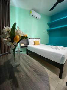 Zimmer mit einem Tisch und einer Vase aus Blumen in der Unterkunft Hotel Murallas Capital in Campeche