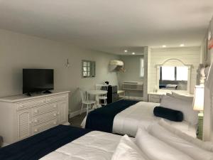 a bedroom with two beds and a flat screen tv at Cape cottage inn in Cape May