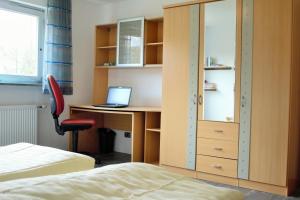 a bedroom with a bed and a desk with a laptop at Ferienhaus Winterberg in Winterberg