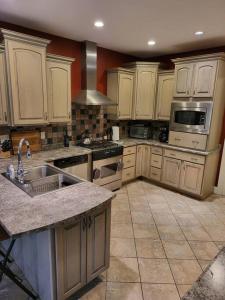 a large kitchen with white cabinets and a sink at 5 Bedroom Bethel Maine home in Bethel
