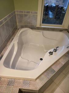 a white bath tub in a bathroom with a window at 5 Bedroom Bethel Maine home in Bethel