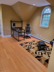 a living room with a desk and chairs on a rug at 5 Bedroom Bethel Maine home in Bethel