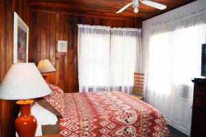 a bedroom with a bed and a lamp and windows at Sunshine Cozy Cottage in Clearwater Beach