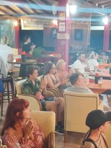 un gruppo di persone seduti su sedie in un ristorante di DAMIA HOTEL Apts a Sidari