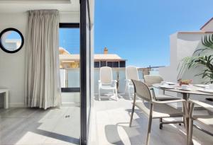 uma sala de jantar com uma mesa e cadeiras numa varanda em North Coast Apartments em Puerto de la Cruz