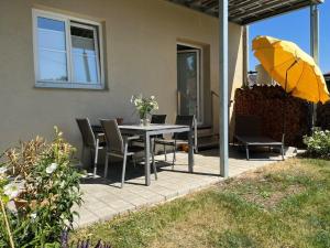 un patio con mesa, sillas y sombrilla en Casa Maria, en Amtzell