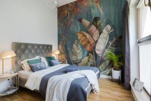 ワルシャワにあるWoronicza Premium - Jungle Warsawのトロピカルな壁紙のベッドルーム1室(大型ベッド1台付)