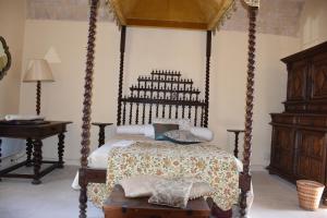 a bedroom with a canopy bed and a table at Prieuré du 17è dans l'Ardèche méridionale in Vagnas