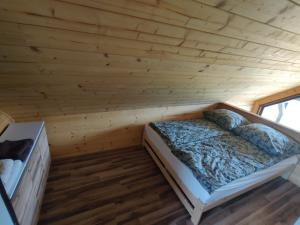 1 dormitorio con 1 cama en una cabaña de madera en Domek nad rzeką Rospuda 