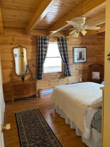 a bedroom in a log cabin with a bed and a mirror at Beautiful Log Home, Lake side. in New Hope