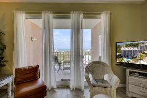 a living room with a window with a view of the ocean at The Dunes 507 by Vacation Homes Collection in Gulf Shores