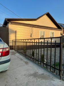 a house with a fence in front of it at The Nest Hostel in Karakol