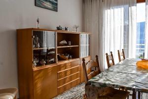 einen Holzschrank in einem Esszimmer mit einem Tisch in der Unterkunft Ciceri Properties Montebello in Verbania