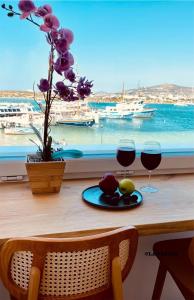 a table with two glasses of wine and a view of the ocean at Nautica Suites - Modern Seaview Suite in Antiparos