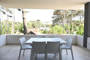 Biały stół i krzesła na balkonie w obiekcie Carilo Vista w mieście Carilo