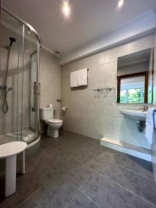 a bathroom with a shower and a toilet and a sink at Pension Anoeta in San Sebastián