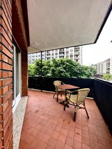 un patio con tavolo e sedie sul balcone. di Pension Anoeta a San Sebastián