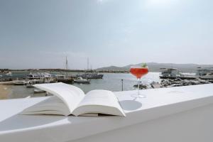 a book and a glass of wine on a table at Nautica Suites - Modern Seaview Suite in Antiparos
