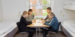 灵克宾灵克宾大宿舍酒店的一群人围坐在房间里的一张桌子旁