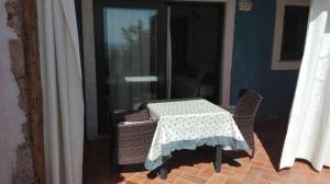 a table and chairs on a patio with a window at Mandorlo 2 in Santa Maria Navarrese +1 photo