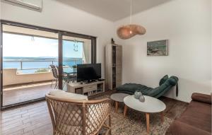 a living room with a couch and a tv and a table at Nice Apartment In Dramalj With House Sea View in Dramalj
