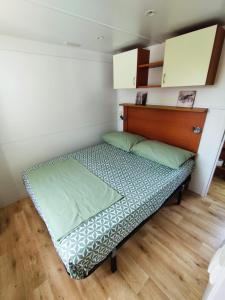 a small bed in a room with a wooden floor at Petra's garden in Kraj