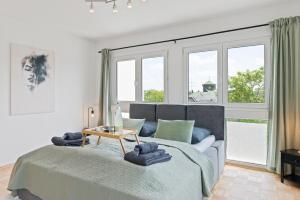 1 dormitorio con cama, mesa y ventanas en Lemon Suites Hildrizhausen - Ideal für Teams und Monteure, en Hildrizhausen