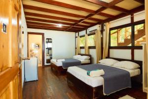um quarto com 2 camas e um frigorífico. em Arrecife Punta Uva - Hospedaje, bar y restaurante - Frente al mar em Punta Uva